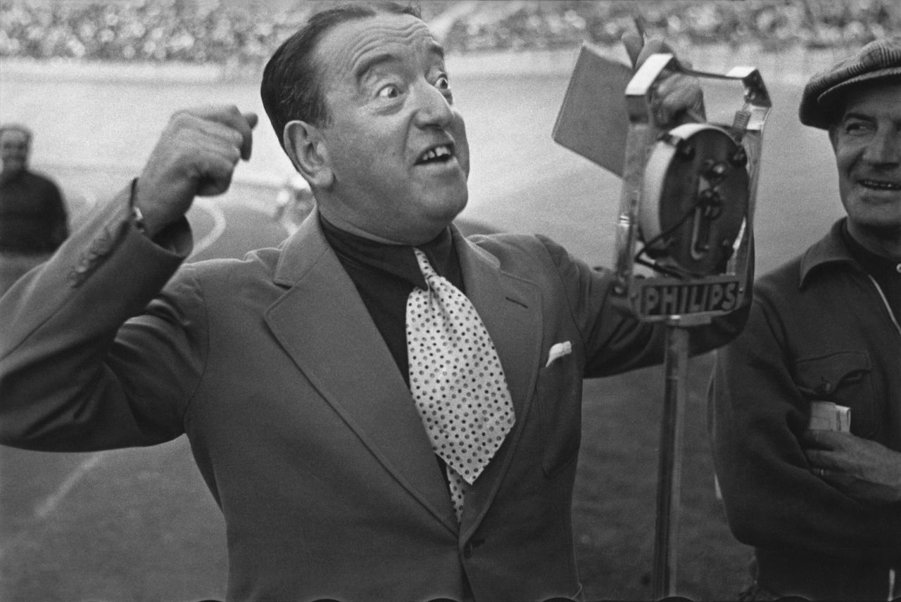 A radio announcer is seen as a team arrives at a stadium. These days, the race is carried live all over the world, including online streaming.