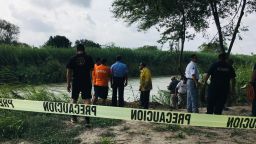Authorities stand behind yellow warning tape along the Rio Grande bank where the bodies of Salvadoran migrant Oscar Alberto Martínez Ramírez and his nearly 2-year-old daughter Valeria were found, in Matamoros, Mexico, Monday, June 24, 2019, after they drowned trying to cross the river to Brownsville, Texas. Martinez' wife, Tania told Mexican authorities she watched her husband and child disappear in the strong current. (AP Photo/Julia Le Duc)