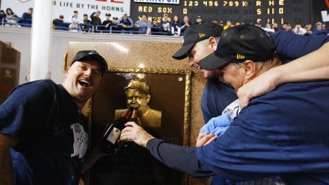David Wells (L), Roger Clemens (C) and pitching coach Mel Stottlemyre celebrate in Yankee Stadium with the plaque of Babe Ruth after defeating the Boston Red Sox in Game 7 of the ALCS in 2003. The Curse of the Bambino would be broken the following year in a playoff rematch between the teams.