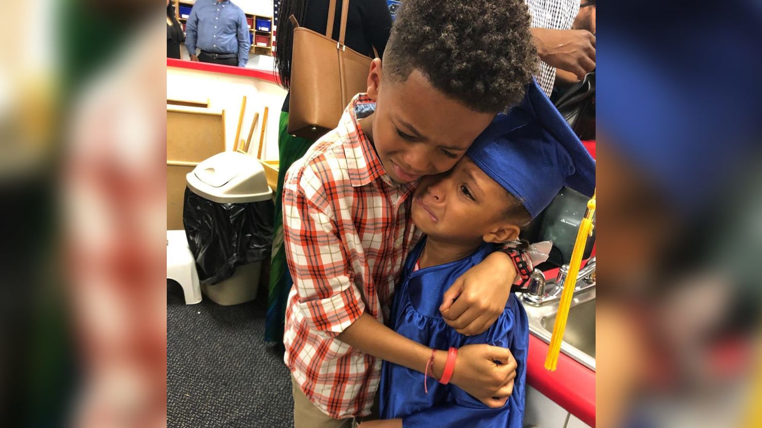 brother hugs sister graduation