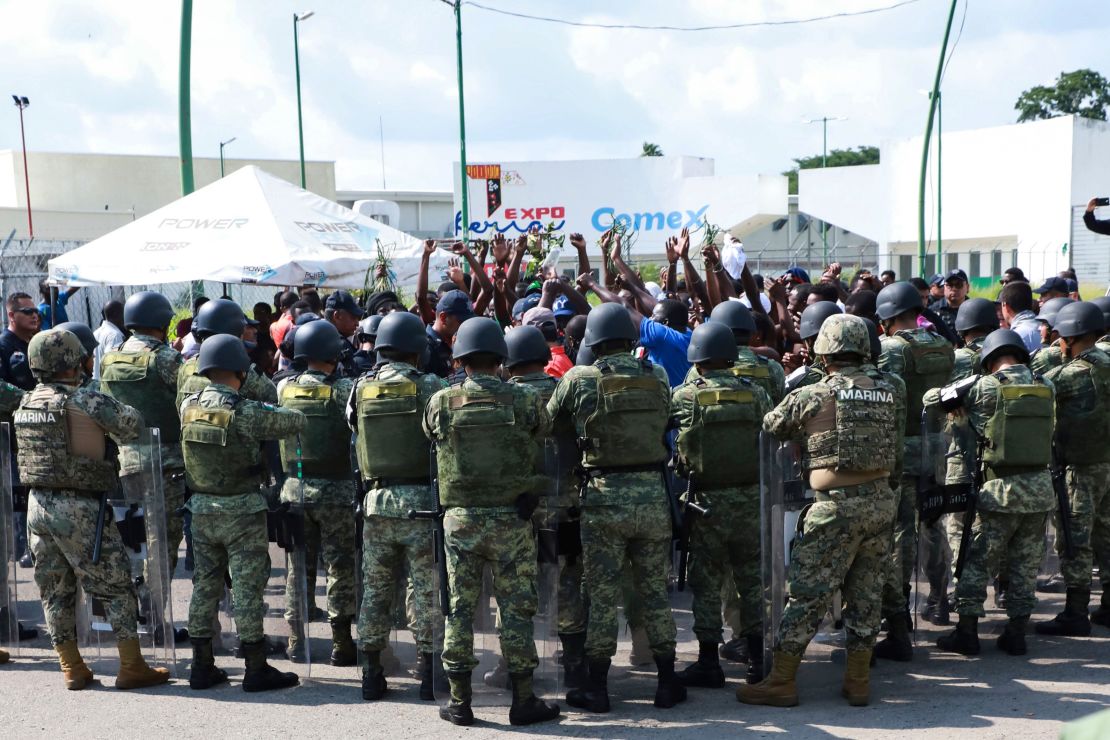 Military officers surround migrants protesting outside a shelter in Tapachula, Mexico, on June 18.