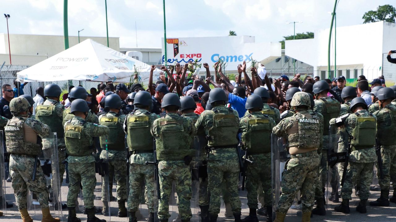Military officers surround migrants protesting outside a shelter in Tapachula, Mexico, on June 18.