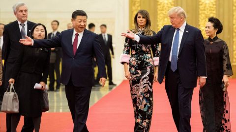 US President Donald Trump gestures toward China's President Xi Jinping, as US First Lady Melania Trump and Xi's wife Peng Liyuan look on in the Great Hall of the People in Beijing on November 9, 2017.