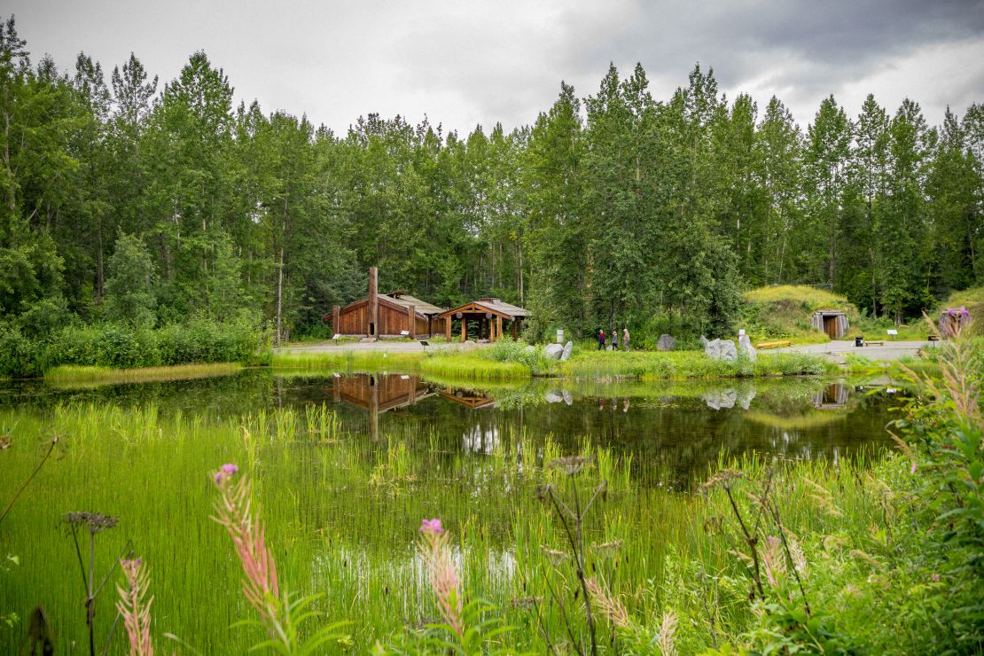 Traditional dwellings surround a lake at the Alaska Native Heritage Center.