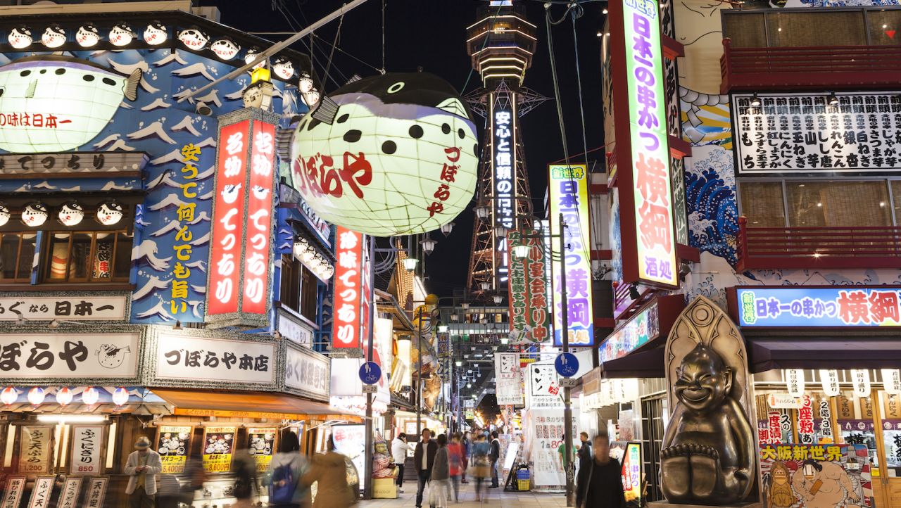 Osaka's colorful Shinsekai neighborhood is a great place to take photos of the illuminated Tsutenkaku Tower after dark.
