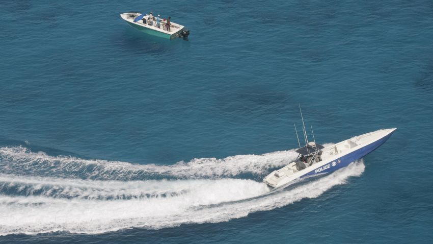 ** ADVANCE FOR WEEKEND OF APRIL 22-23 **A Royal Bahamas police speedboat, lower right, speeds in to check out a suspicious vessel near a possible drug drop zone Thursday, April 6, 2006, in the Bahamas. (AP Photo/Wilfredo Lee)