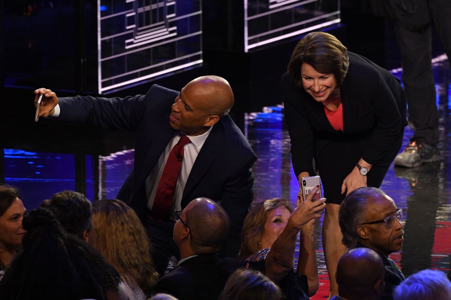 Booker and Klobuchar take selfies with supporters after Wednesday's debate.