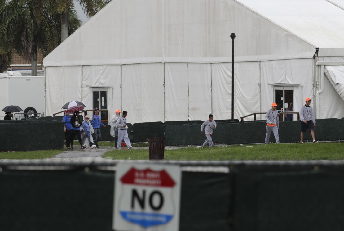 Migrant children and employees walk on the grounds of the Homestead shelter in Florida. 