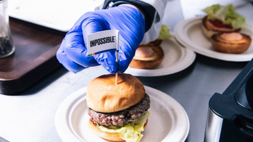 A technician places a flag toothpick into a burger with an Impossible burger patty at the test kitchen inside Impossible Foods headquarters in Redwood City, Calif. on Thursday, June 20, 2019.