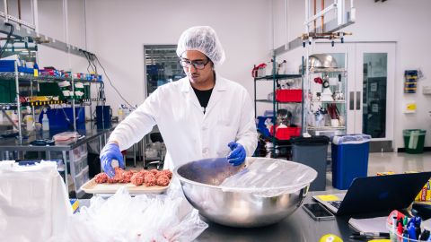 A technician weighs a tray of Impossible meatballs inside the test kitchen.
