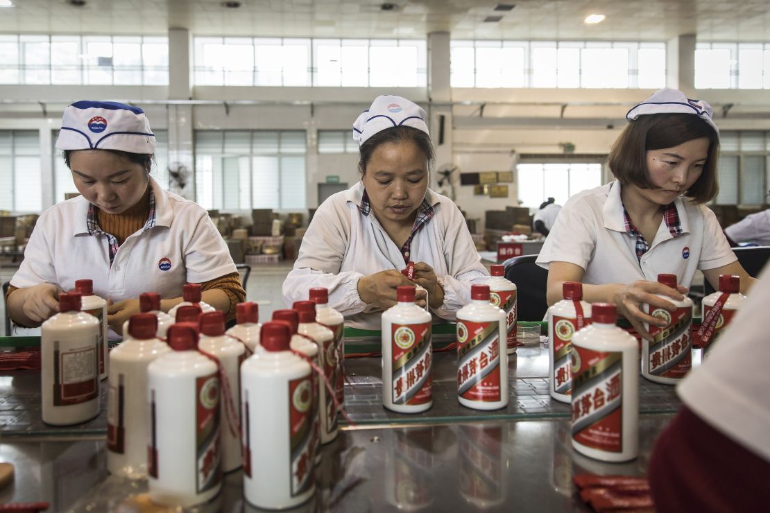 Employees tie ribbons onto bottles of Moutai baijiu at the Kweichow Moutai factory in Guizhou province, China, in 2017.