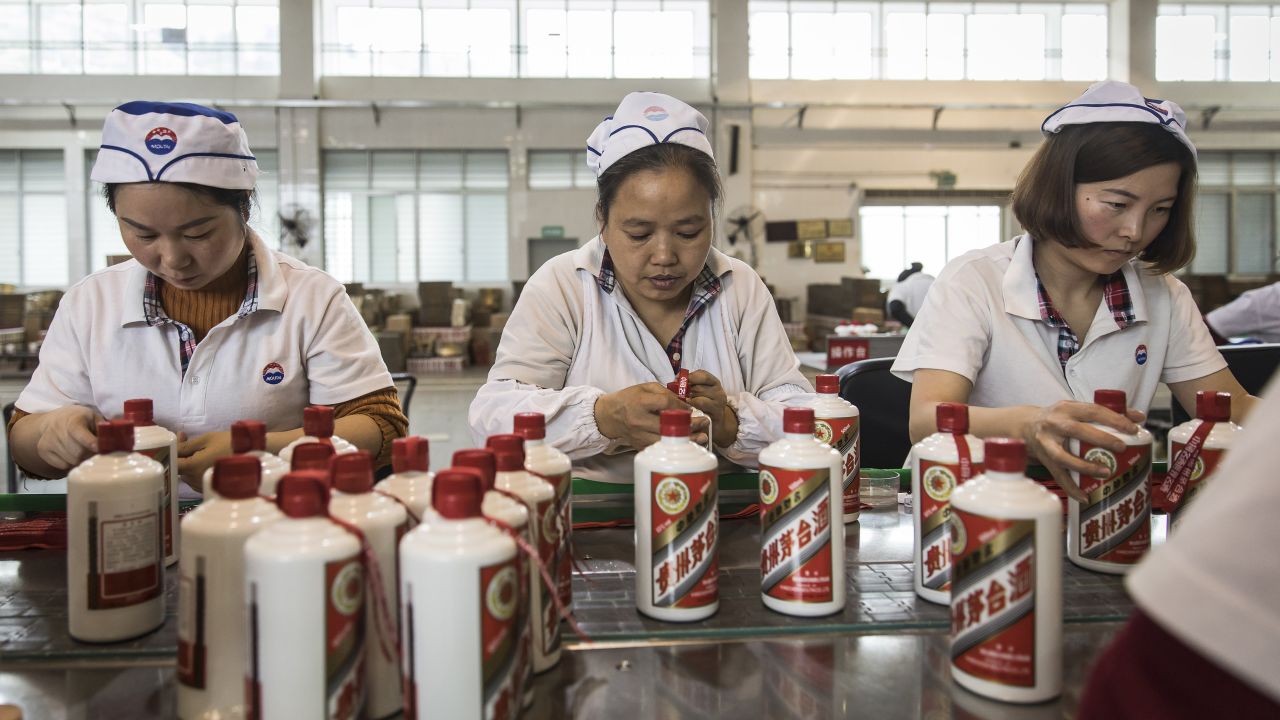 Employees tie ribbons onto bottles of Moutai baijiu at the Kweichow Moutai factory in Guizhou province, China, in 2017.