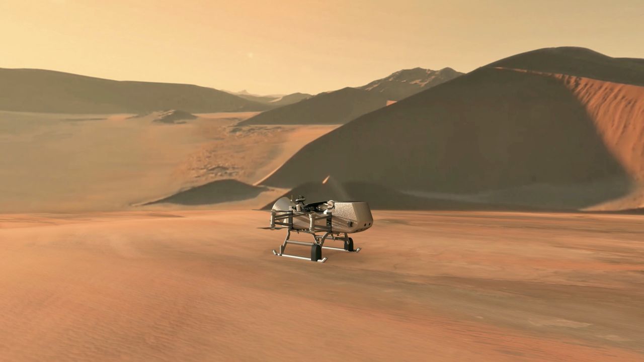 This illustration shows NASA's Dragonfly rotorcraft-lander approaching a site on Saturn's exotic moon, Titan. Taking advantage of Titan's dense atmosphere and low gravity, Dragonfly will explore dozens of locations across the icy world. It will launch in 2026, but won't reach Titan until 2034 because Saturn is so far from us.