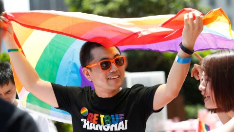 A participant holds a rainbow flag after taking part in a Pride event in Shanghai on June 17, 2017. 