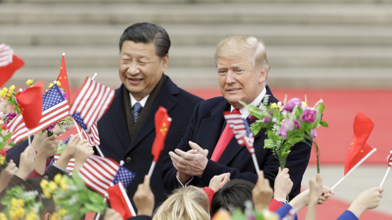 US President Donald Trump, right, and Xi Jinping, China's president, greet attendees waving American and Chinese national flags during a welcome ceremony outside the Great Hall of the People in Beijing, China, on Thursday, Nov. 9, 2017. Photographer: Qilai Shen/Bloomberg via Getty Images