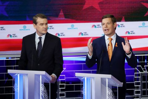 Bennet watches Swalwell speak on Thursday. Swalwell, a four-term congressman from California's Bay Area, has made combating gun violence a focus for months, and he said it will be the top focus of his campaign. <a href="https://www.cnn.com/politics/live-news/democratic-debate-june-27-2019/h_37e0b86709474a8520e8329c0df8e278" target="_blank">The orange ribbon on his lapel</a> was worn to honor the victims of the Parkland, Florida, school shooting last year.