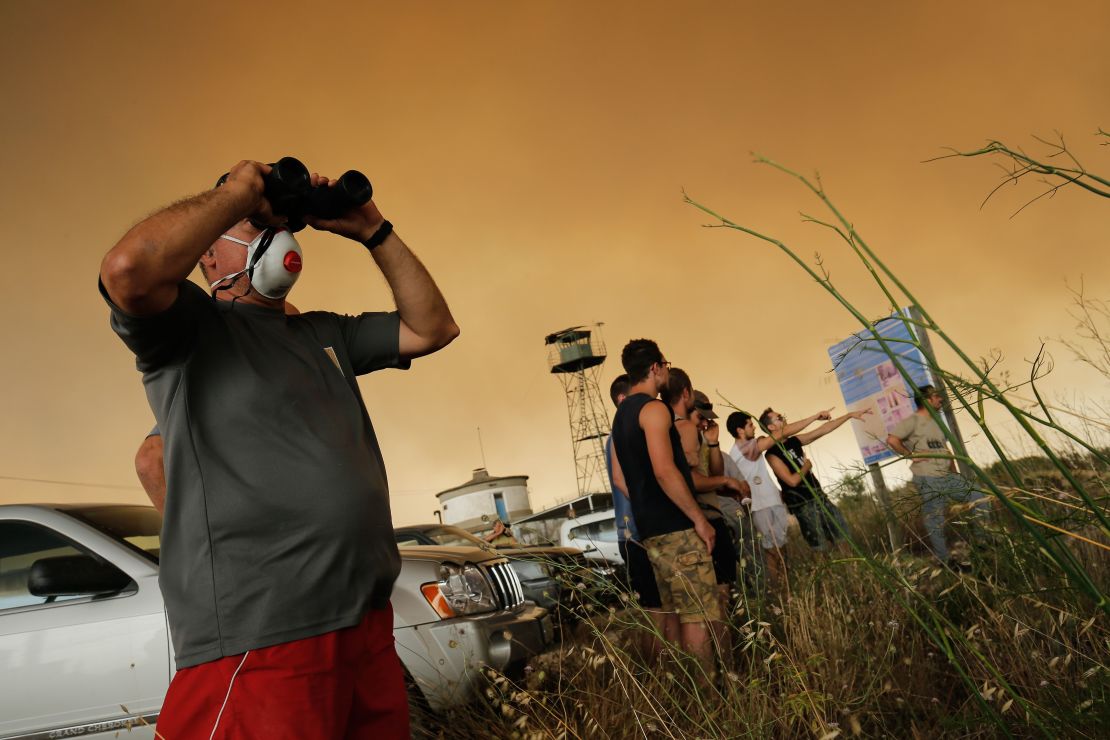 Residents gather to observe a forest fire raging near Maials in the northeastern region of Catalonia on June 27, 2019. 