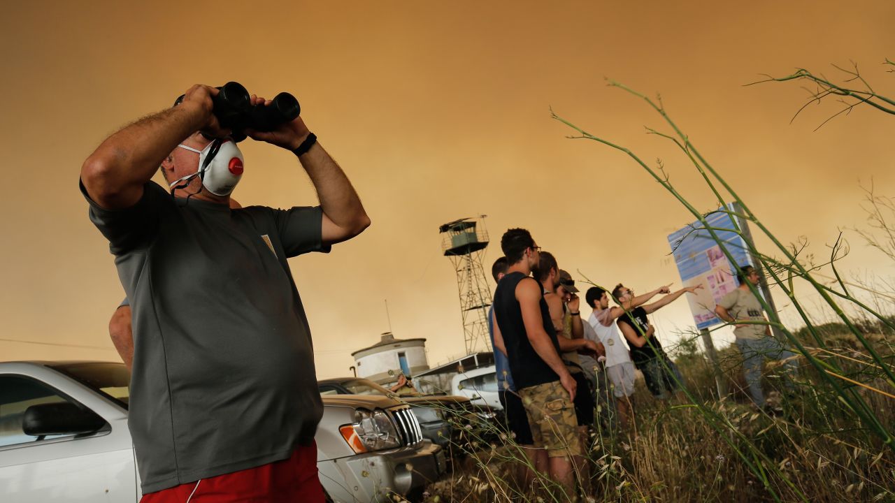 Residents gather to observe a forest fire raging near Maials in the northeastern region of Catalonia on June 27, 2019. 