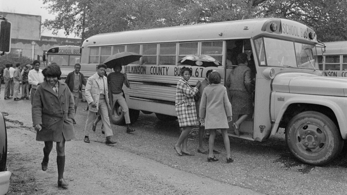 Black students in Woodville, Mississippi, board a school bus for their first day at a formerly white school.