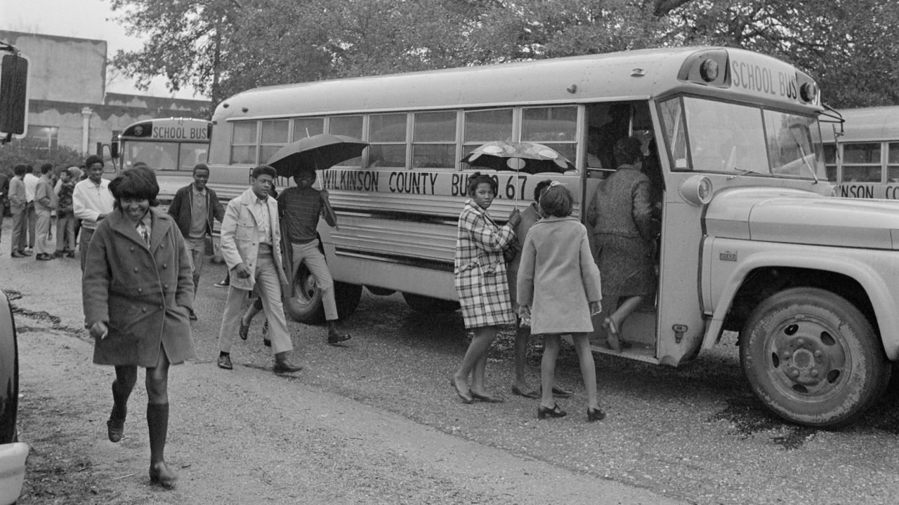 Black students in Woodville, Mississippi, board a school bus for their first day at a formerly white school.