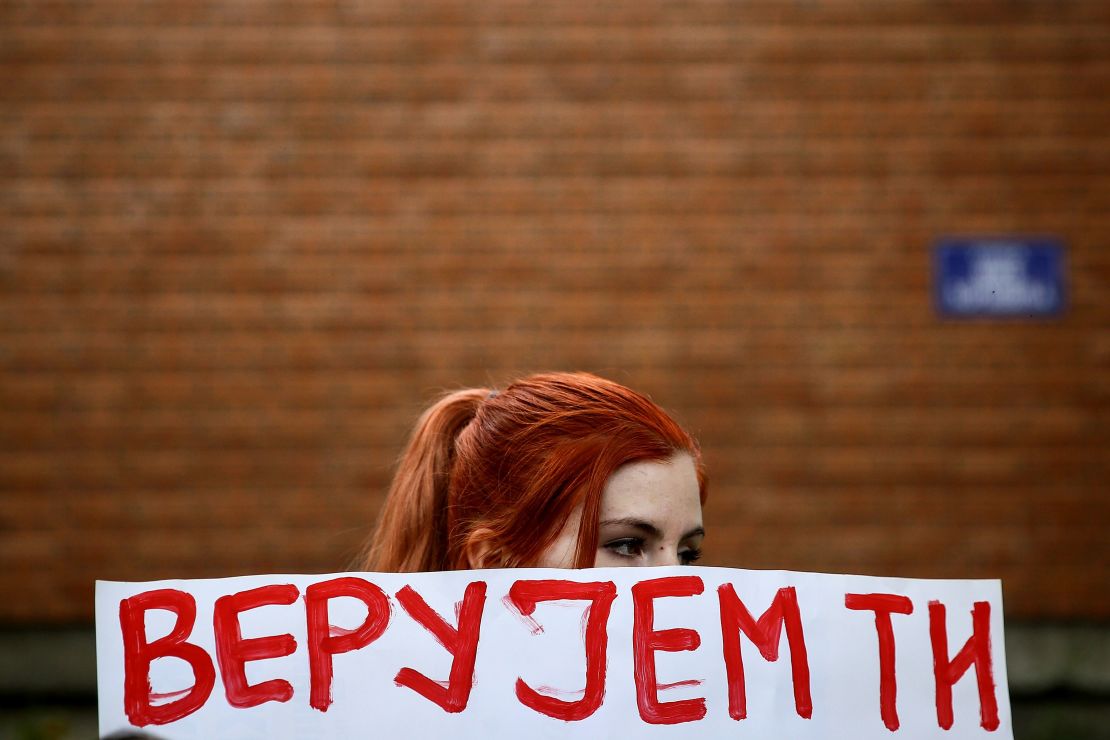 A woman holds a banner reading "I trust you" during a rally in support of Marija Lukic in front of court.