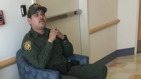 A border agent sits outside the hospital room of an 16-year-old migrant girl.