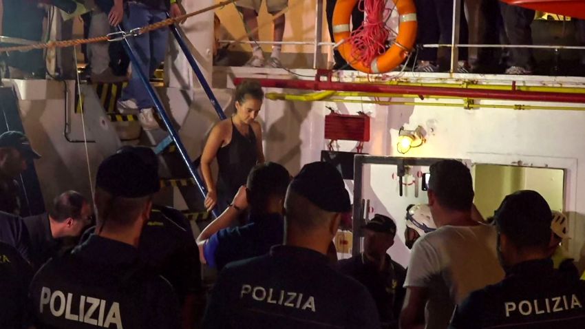 An image grab taken from a video released by Local Team on June 29, 2019, shows the Sea-Watch 3 charity ship's German captain Carola Rackete being arrested by Italian police, in the Italian port of Lampedusa, Sicily. - The Sea-Watch 3 charity ship carrying dozens of migrants rescued off Libya forced its way into the Italian port of Lampedusa on June 28 night after a lengthy standoff, the charity said. The boat's German captain Carola Rackete, 31, was arrested and the 40 migrants were still on board after the vessel docked. After manoeuvring the ship into port without permission, Rackete was arrested by police for refusing to obey a military vessel, a crime punishable by between three and 10 years in jail. She offered no resistance and was escorted off the vessel without  handcuffs. (Photo by Anaelle LE BOUEDEC / various sources / AFP) / Italy OUT        (Photo credit should read ANAELLE LE BOUEDEC/AFP/Getty Images)