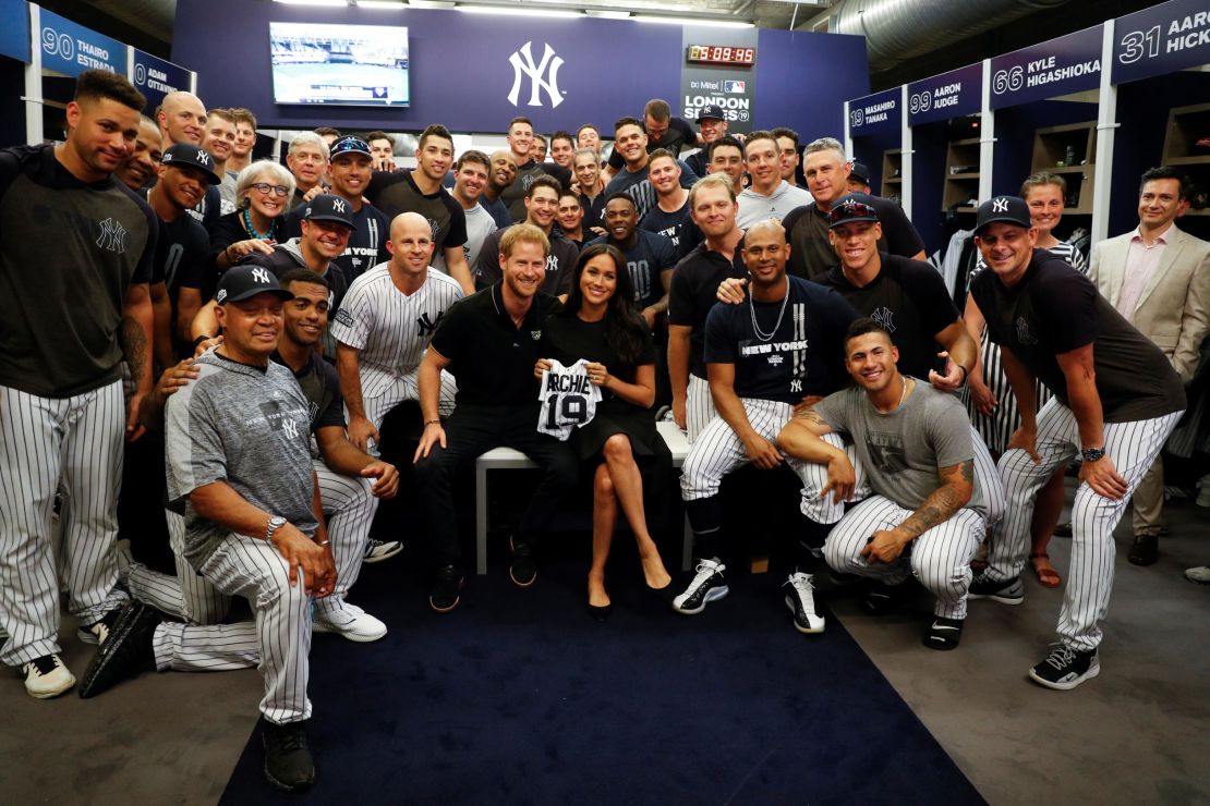 Harry and Meghan display the mini Yankees jersey the team gifted to their son Archie. 