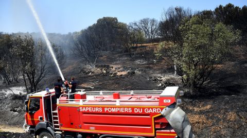 Firefighters put out hot spots on Saturday after a brushfire hit the south on France.