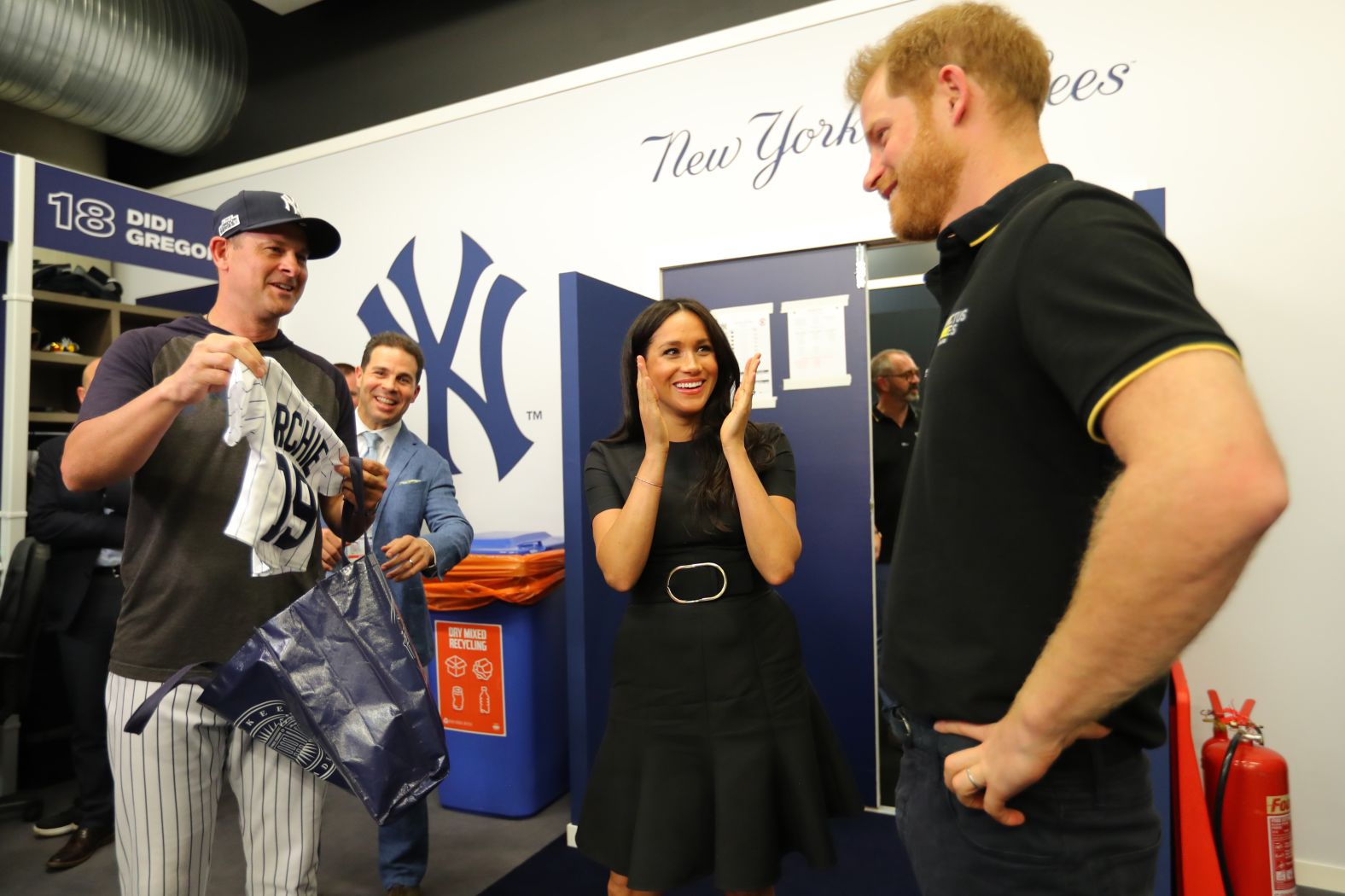 New York Yankees manager Aaron Boone, left, presents Meghan, Duchess of Sussex, and Prince Harry, Duke of Sussex, with a gift for their son Archie prior to game one on June 29.