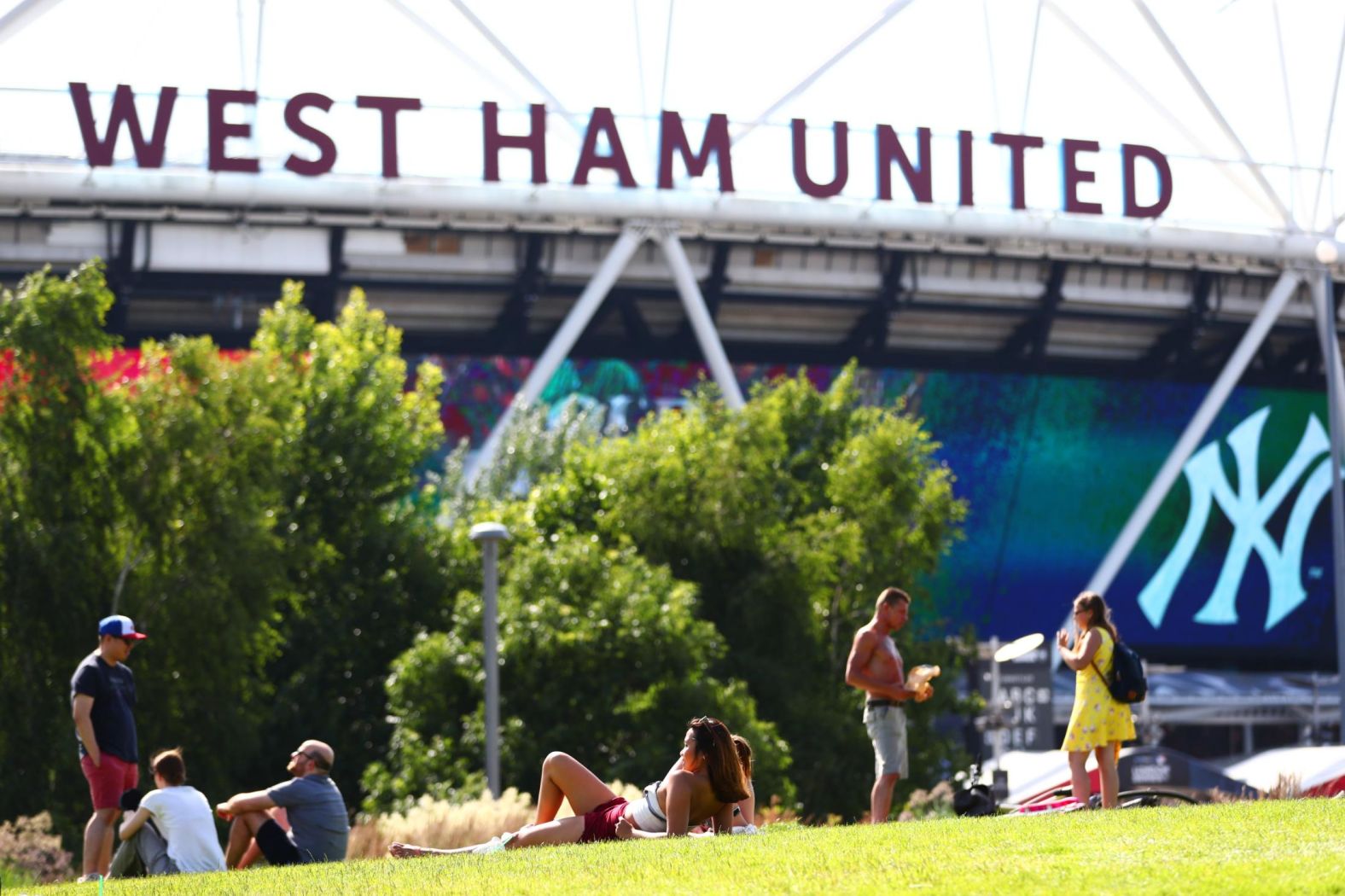 Fans bask in the sunshine outside of London Stadium on June 29.