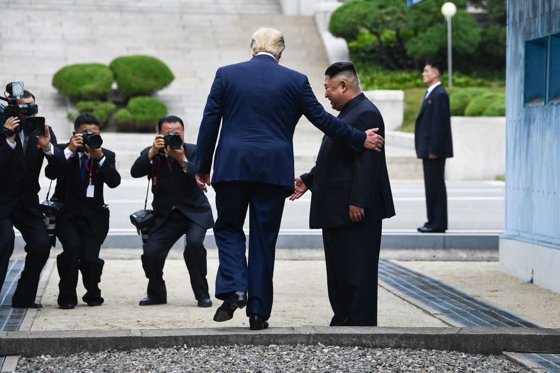 US President Donald Trump steps into the northern side of the Military Demarcation Line that divides North and South Korea as North Korea's leader Kim Jong Un looks on. 