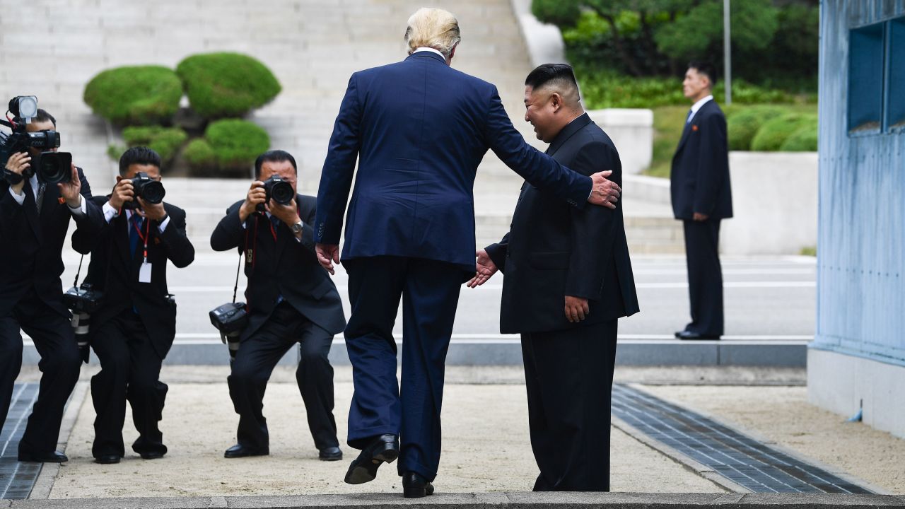US President Donald Trump steps into the northern side of the Military Demarcation Line that divides North and South Korea as North Korea's leader Kim Jong Un looks on. 