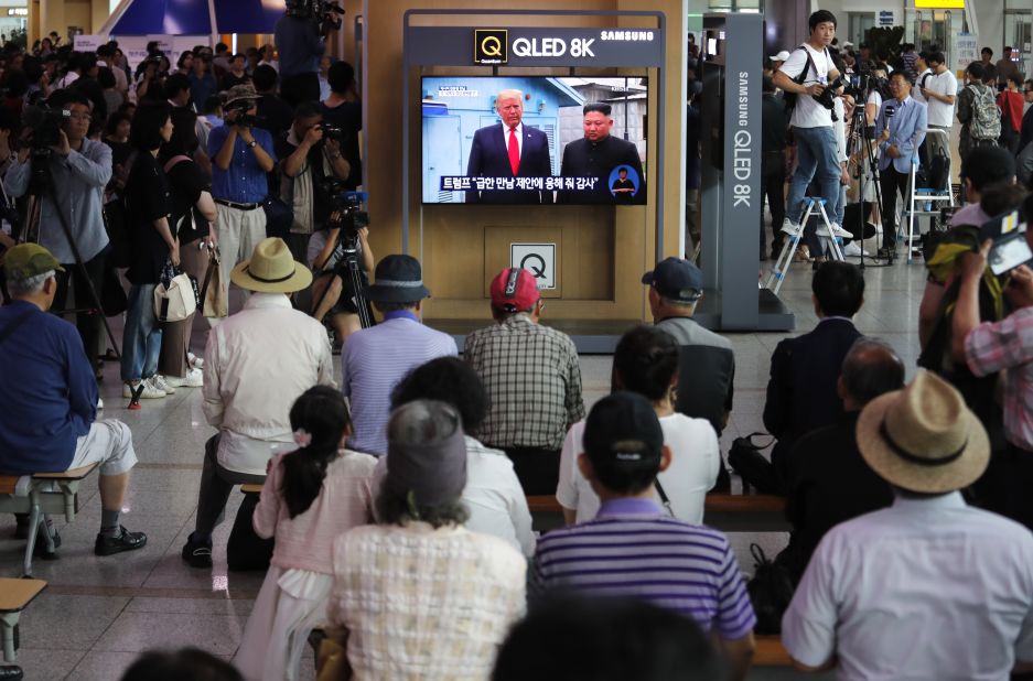 People at the Seoul Railway Station watch a news program on a TV screen showing Trump and Kim at the border village of Panmunjom on June 30. 