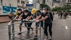 Anti-extradition protesters move barricades on a street outside the Legislative Council Complex ahead of the annual flag raising ceremony of 22nd anniversary of the city's handover from Britain to China on July 1, 2019 in Hong Kong, China. Pro-democracy demonstrators in Hong Kong have organized rallies over the past weeks, calling for the withdrawal of a controversial extradition bill, the resignation of the territory's chief executive Carrie Lam, an investigation into police brutality, and drop riot charges against peaceful protesters. (Photo by Anthony Kwan/Getty Images)