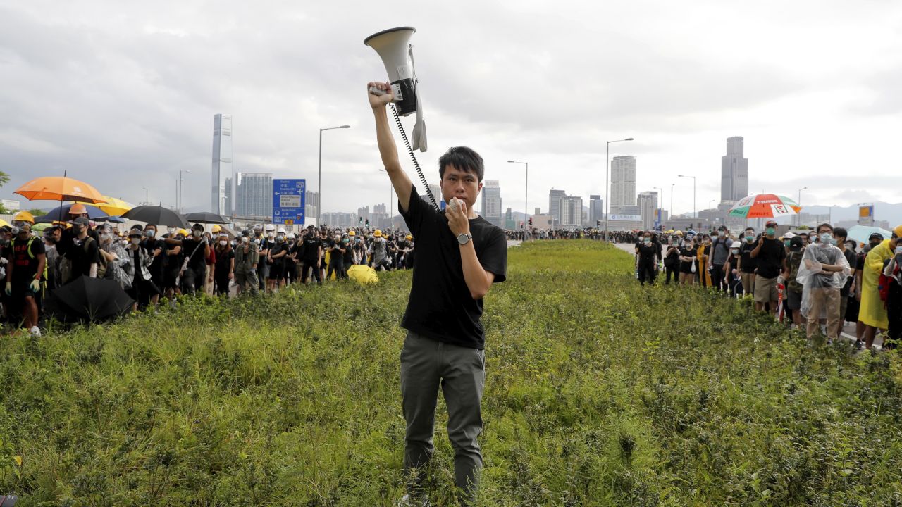 Pro-democracy lawmaker Roy Kwong Chun-yu speaks over a loud hailer to the police as he joins protesters in Hong Kong on Monday.