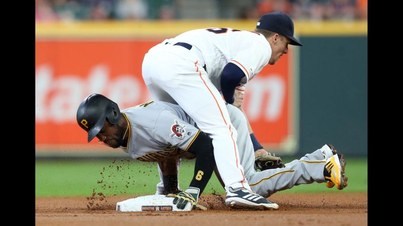 Pittsburgh Pirates center fielder Starling Marte slides safely into second base against Houston Astros shortstop Myles Straw in the first inning of their baseball game at Minute Maid Park in Houston, Texas, on Thursday, June 27.