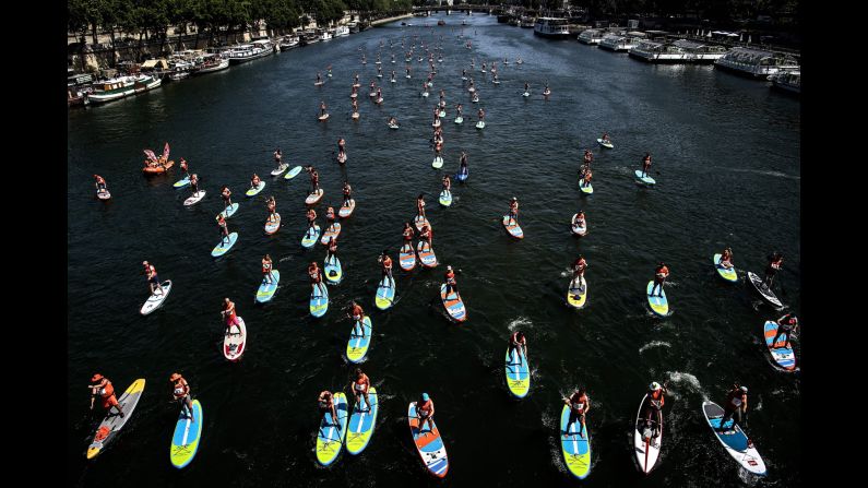 Participants compete in a stand-up paddle rally organized by the National Society of Sea Rescue on the Seine river in Paris, France, on June 28.