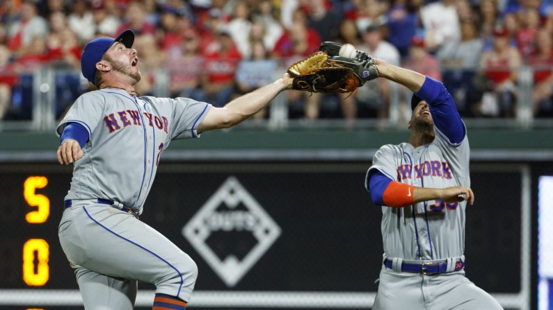 New York Mets first baseman Pete Alonso, left, and right fielder Michael Conforto reach for a pop foul by Philadelphia Phillies' Sean Rodriguez during the eighth inning of a baseball game, in Philadelphia on Wednesday, June 26.