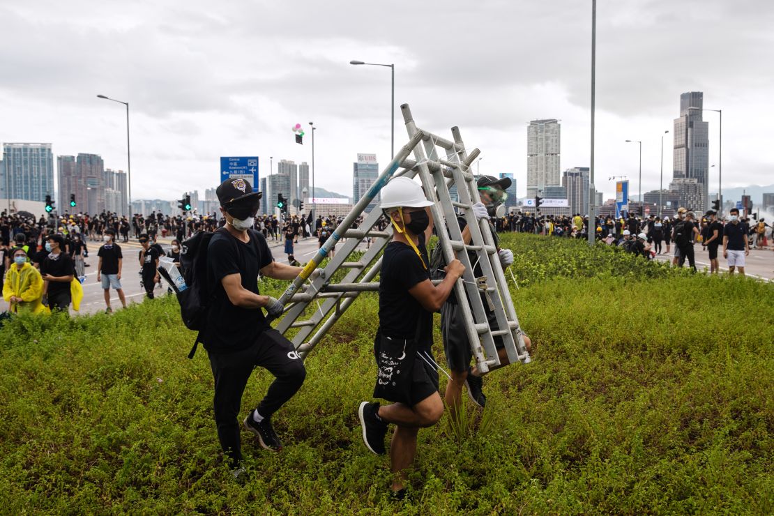 Demonstrators carry a barricade during a protest in Hong Kong, China, on Monday, July 1, 2019. 