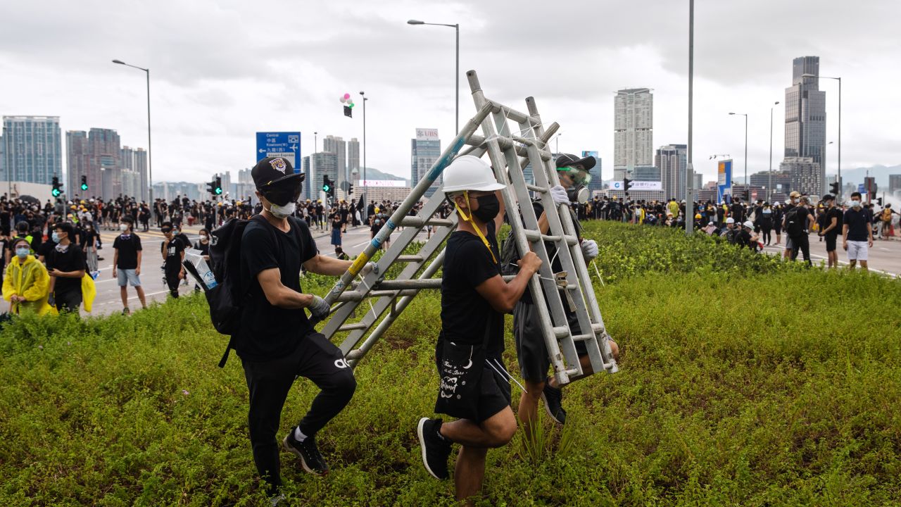 Demonstrators carry a barricade during a protest in Hong Kong, China, on Monday, July 1, 2019.
