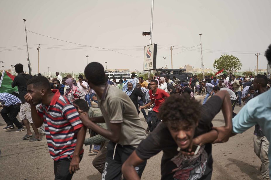 Protesters run from a police van that drove through a crowd on June 30 in Khartoum. The protesters faced off with armed forces on a main road leading to the airport.