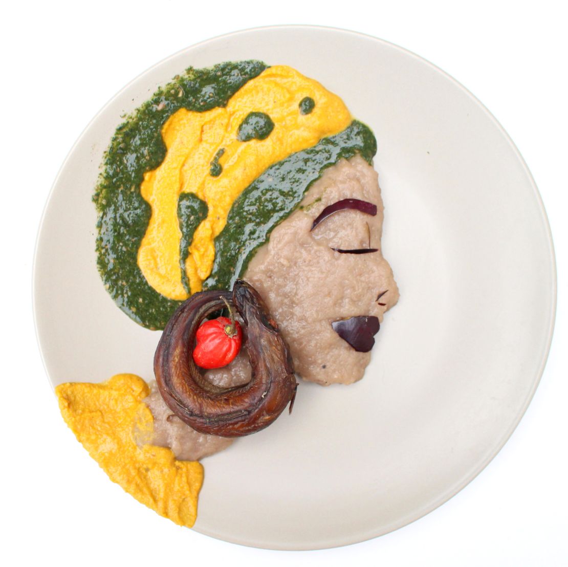 A portrait made with dry fish, pepper, amala (cooked yam flour) and ewedu soup (cooked corchorus leaves).