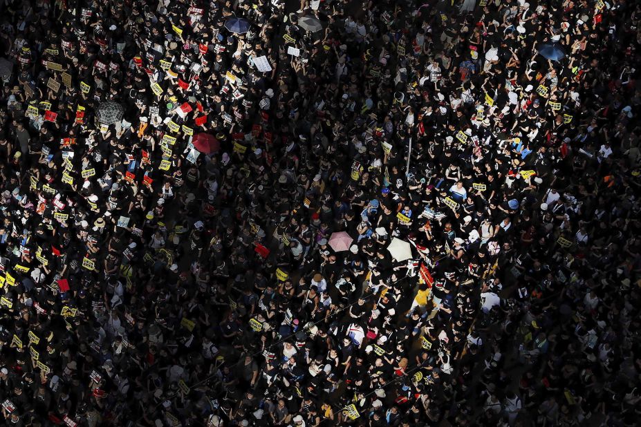 Columns of sunlight are cast on a crowd during the march on July 1.