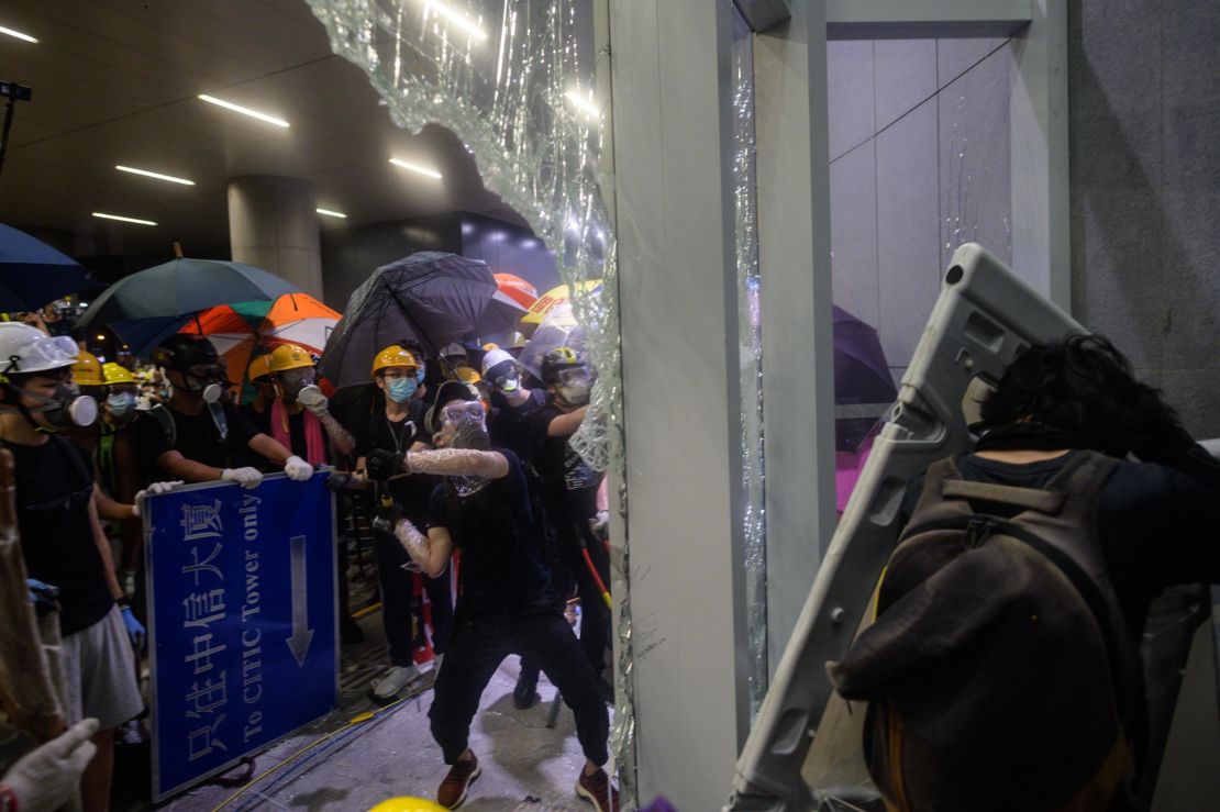 This picture taken on July 1, 2019 shows protesters smashing glass doors and windows of the legislature in Hong Kong.