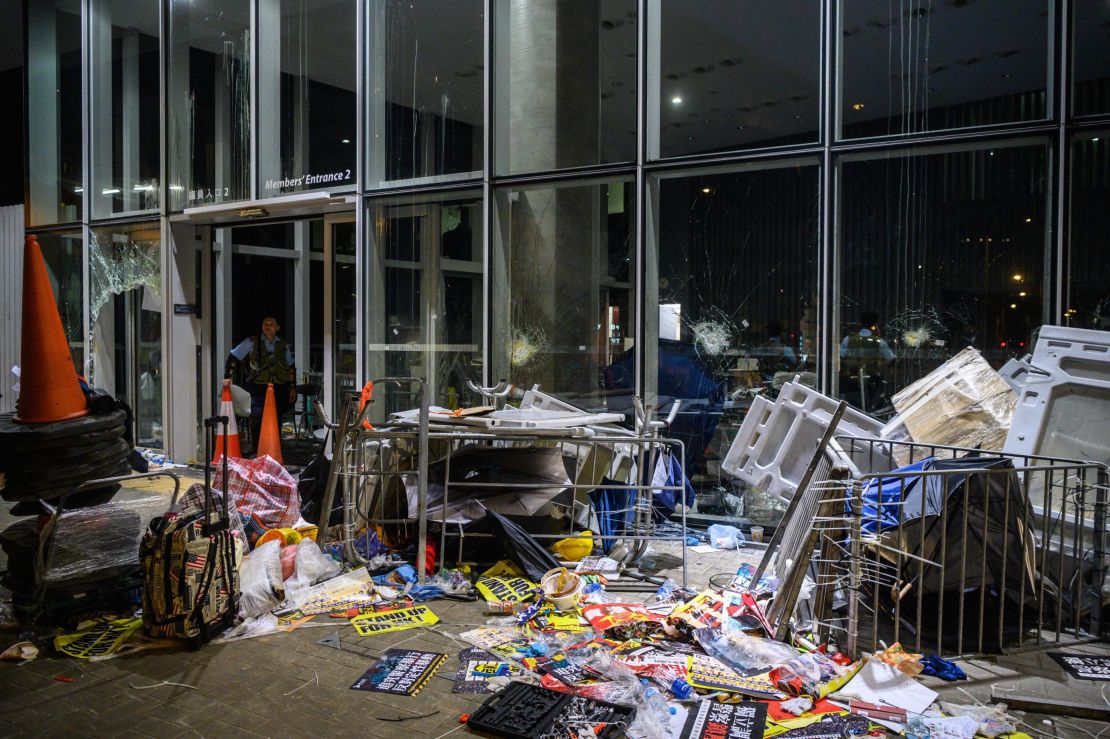 A policeman looks at the damage and debris after protesters stormed the legislature hours before in Hong Kong early on July 2, 2019. 