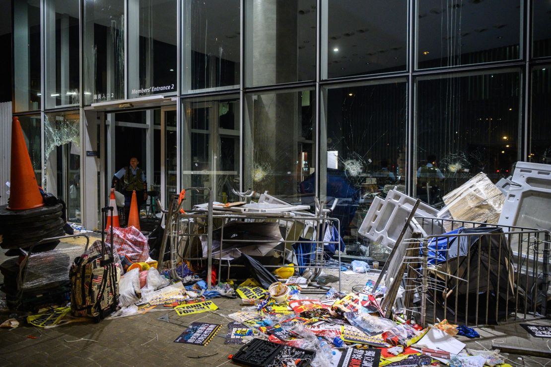 A policeman looks at the damage and debris after protesters stormed the legislature hours before in Hong Kong early on July 2, 2019.