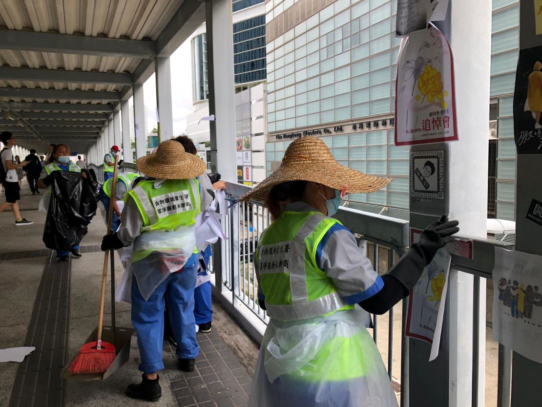 Cleaners remove posters from a footbridge near the Legislative Council building on July 2, 2019.