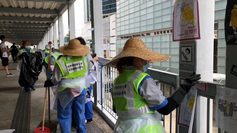 Cleaners remove posters from a footbridge near the Legislative Council building on July 2, 2019.