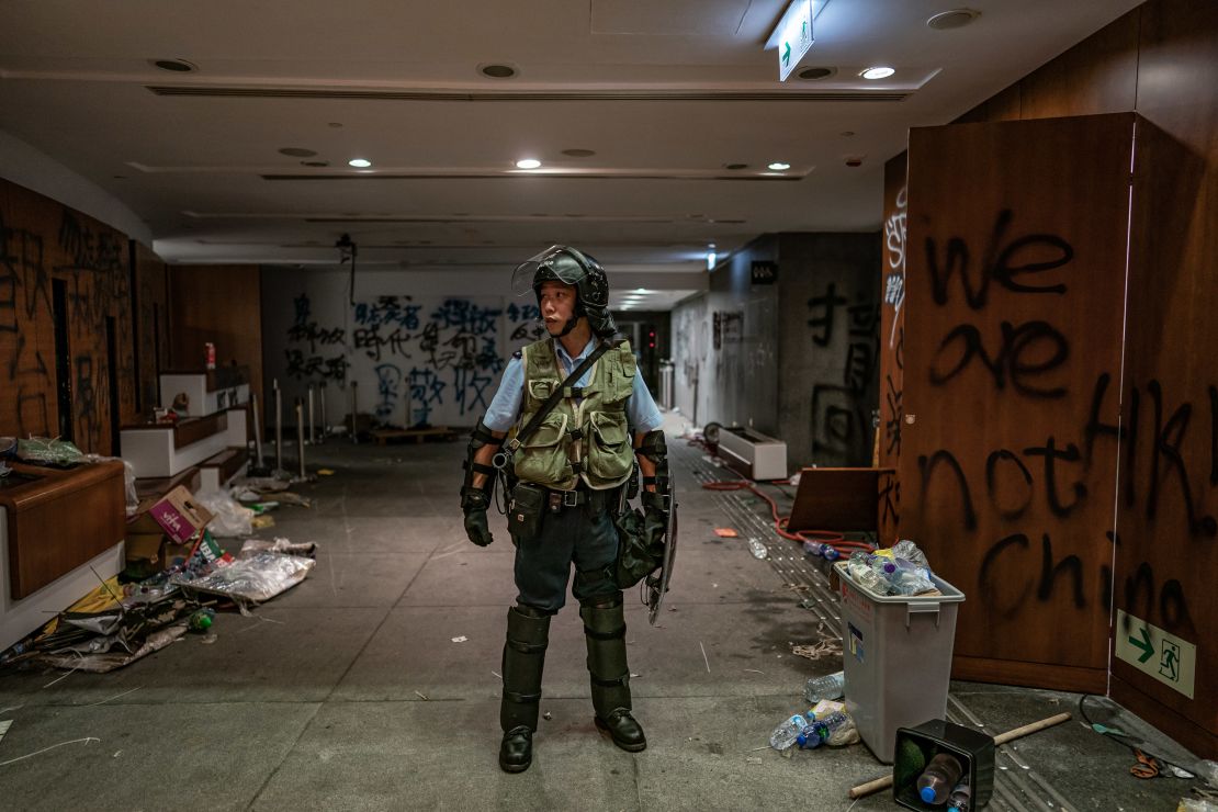 A riot police stands near graffiti inside the Legislative Council building after it was damaged by demonstrators during a protest on July 2 in Hong Kong.